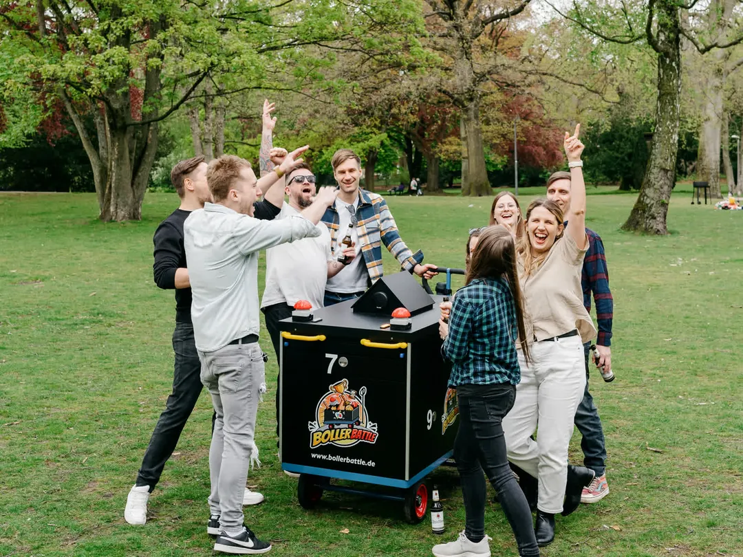 Eine Gruppe jubelt gemeinsam am Battle-Wagen im Park